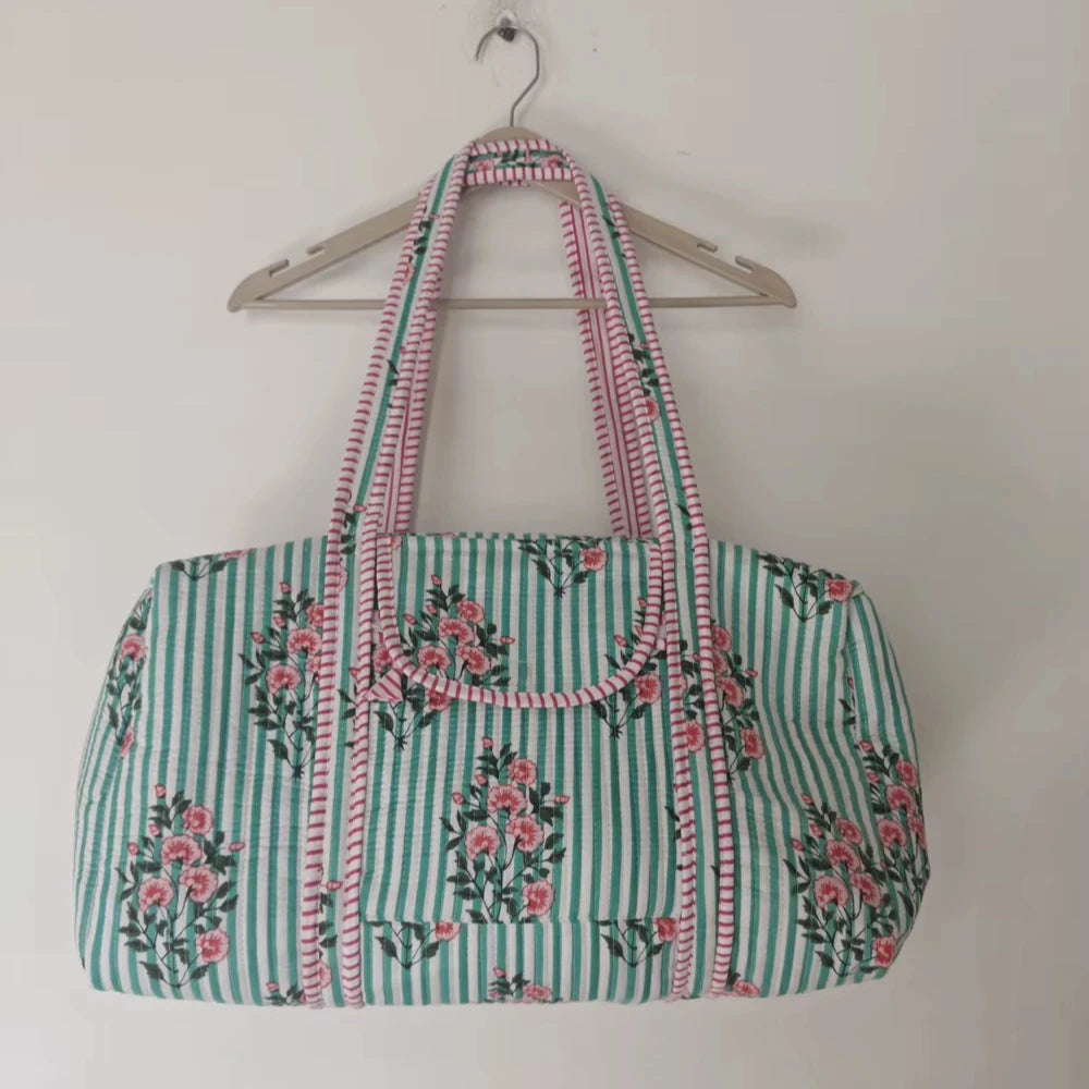 Quilted floral weekender duffle bag in light green stripes with pink floral print and artisan patchwork design.