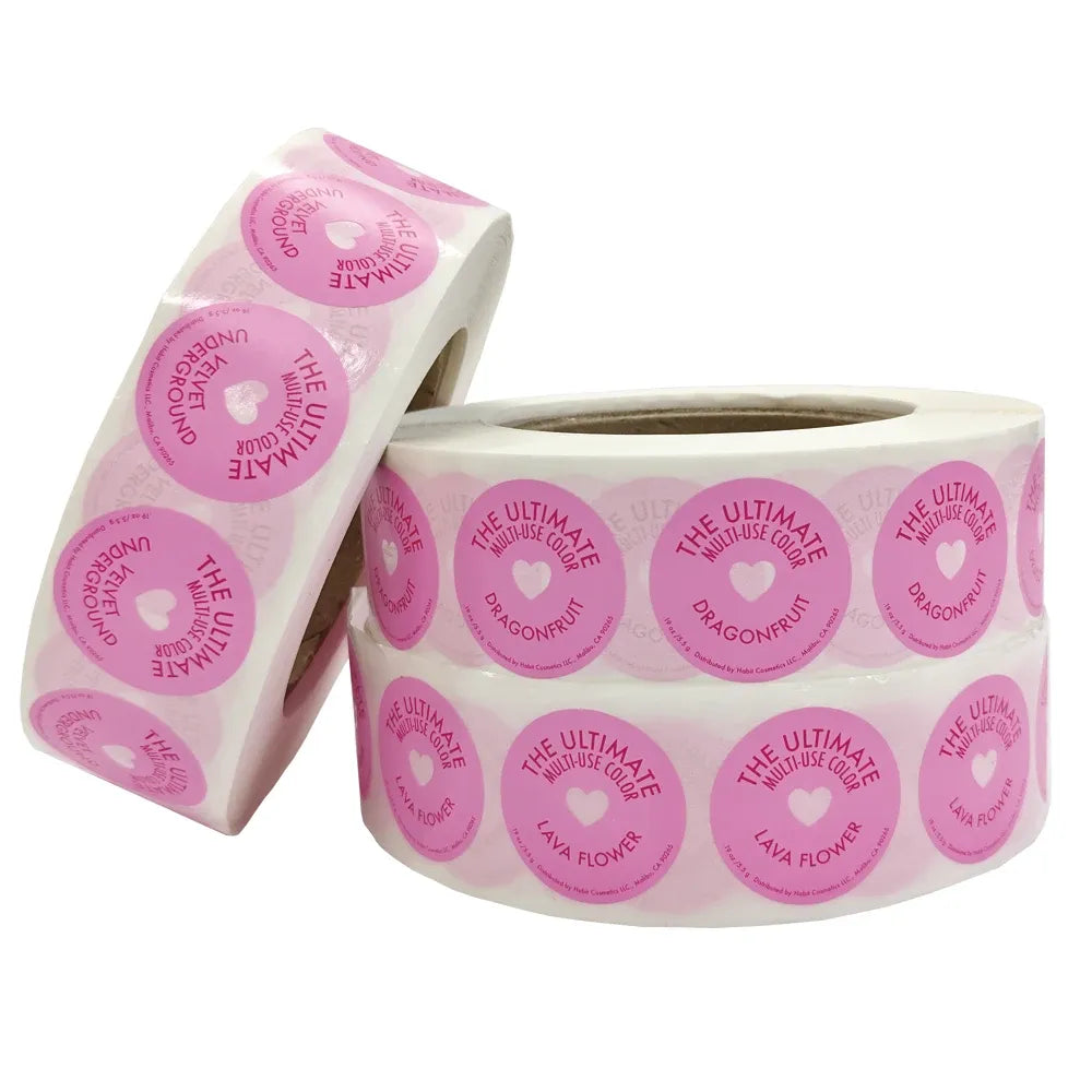 Pink round adhesive label sticker roll with repeated circular print on clear backing
