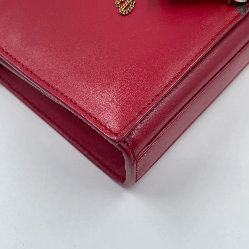 Luxury red genuine leather designer handbag, square shoulder bag style with gold chain detail.
