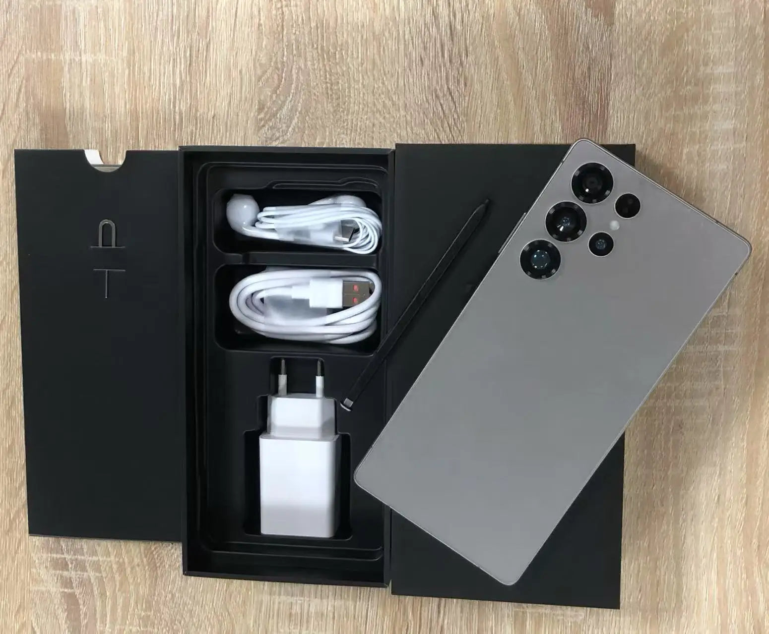 7.3-inch Android smartphone unboxed with USB cable, charger, and silver rear phone