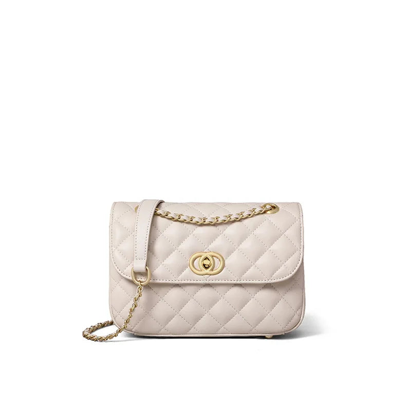 Beige quilted leather crossbody bag with gold chain strap and turn-lock flap closure, modern evening trunk purse.