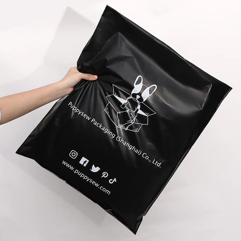 Black poly mailer held open by hand, featuring bunny logo and social icons