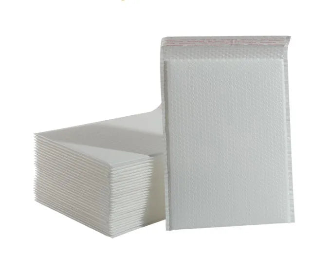 Light gray plastic bubble mailer envelopes stacked with textured bubble surface