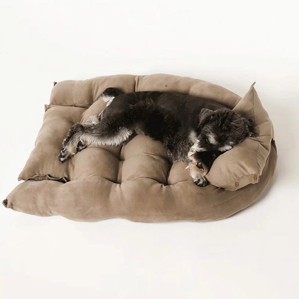 Dog sleeping on a cozy, tan plush sofa bed for cats and dogs. Soft, warm winter pet mattress for ultimate comfort.