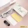 Light grey cat-eye reading glasses with a matching hard case, cleaning cloth, and a small screwdriver tool.