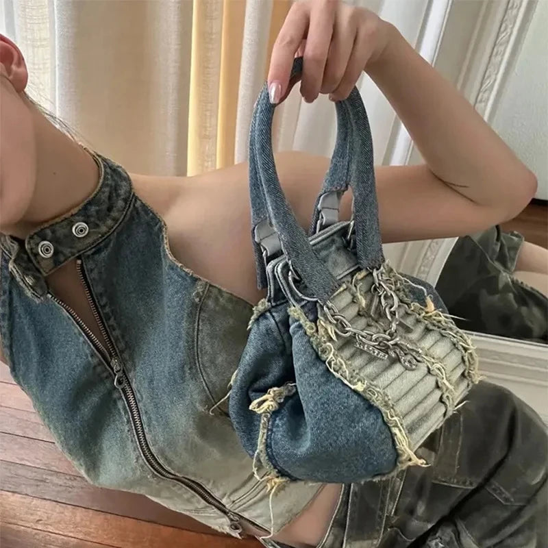 Vintage washed denim hobo trunk bag with frayed edges and chain hardware accents. Stylish casual small designer purse.