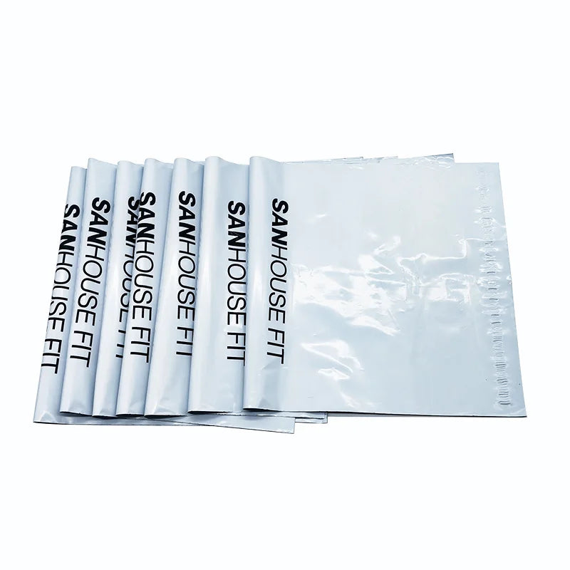 White padded poly mailer bags with repeated black logo text, stacked set