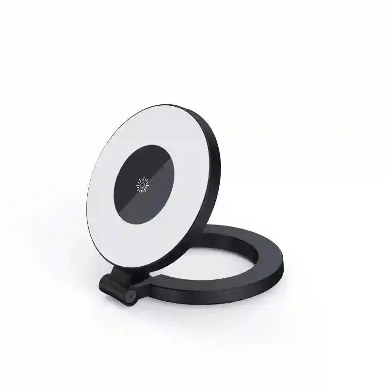 Black and white foldable LED ring light on a circular base, used for desktop lighting or photography.