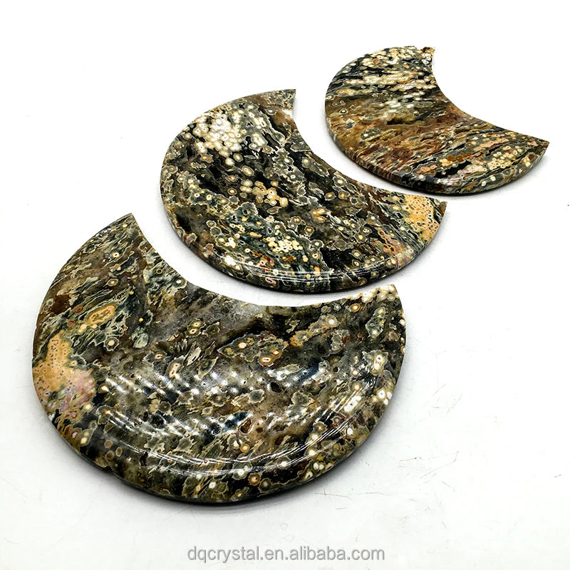 Polished ocean jasper crescent moon crystal with gold-speckled druzy pattern on white display