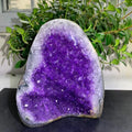 Large amethyst geode crystal cluster with glittering purple crystal surface