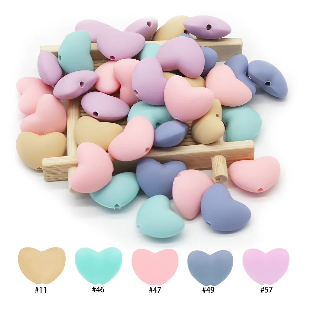Multi-colored silicone heart beads for baby teething toy making.