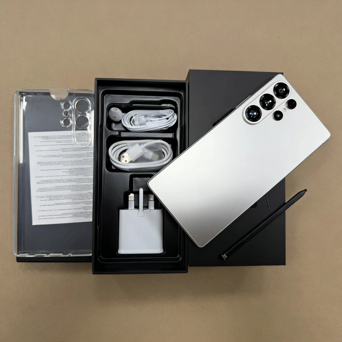 Smartphone box contents display: phone, earbud cables, charger, and instruction sheet