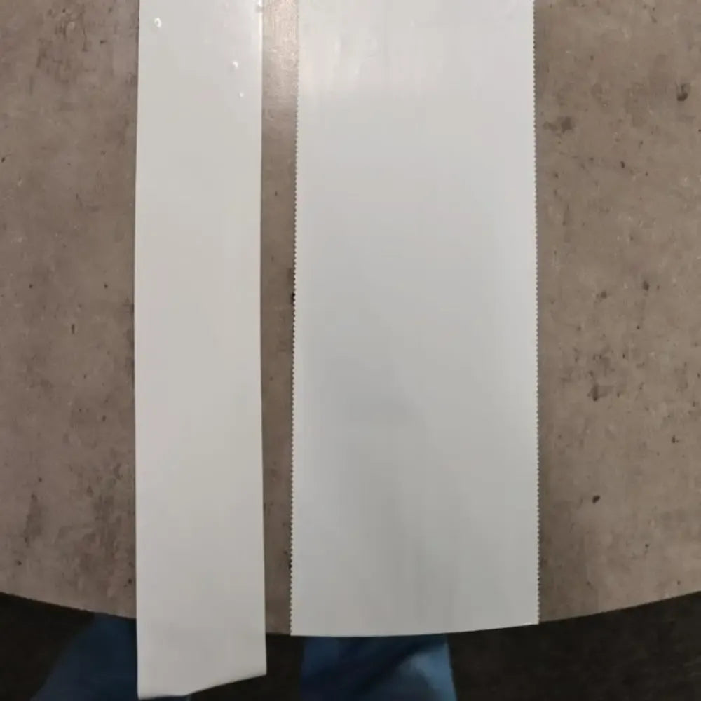 Long strips of white PE shrink wrap repair tape hanging vertically