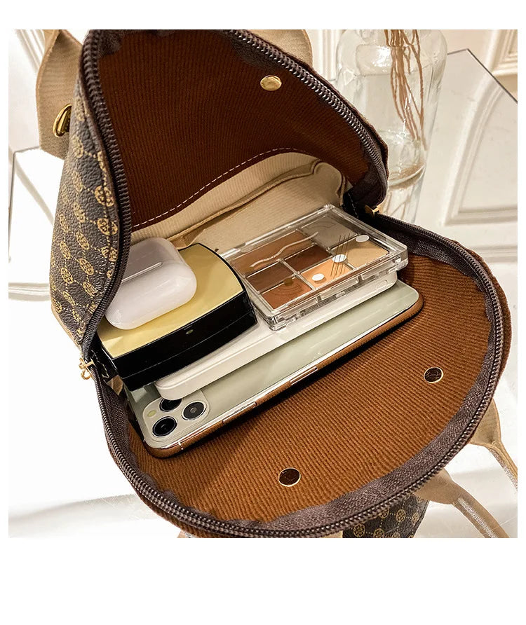 Open brown designer shell handbag with monogram pattern, zipper closure, and spacious interior for daily essentials.