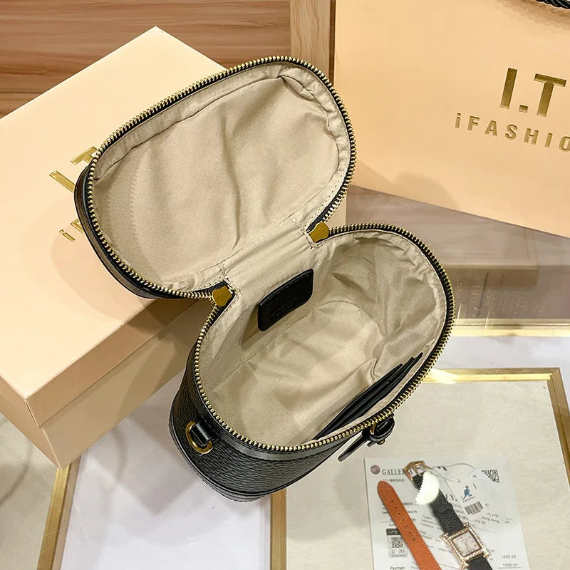 Black caviar cowhide leather vanity trunk bag with beige interior lining and gold zip closure.