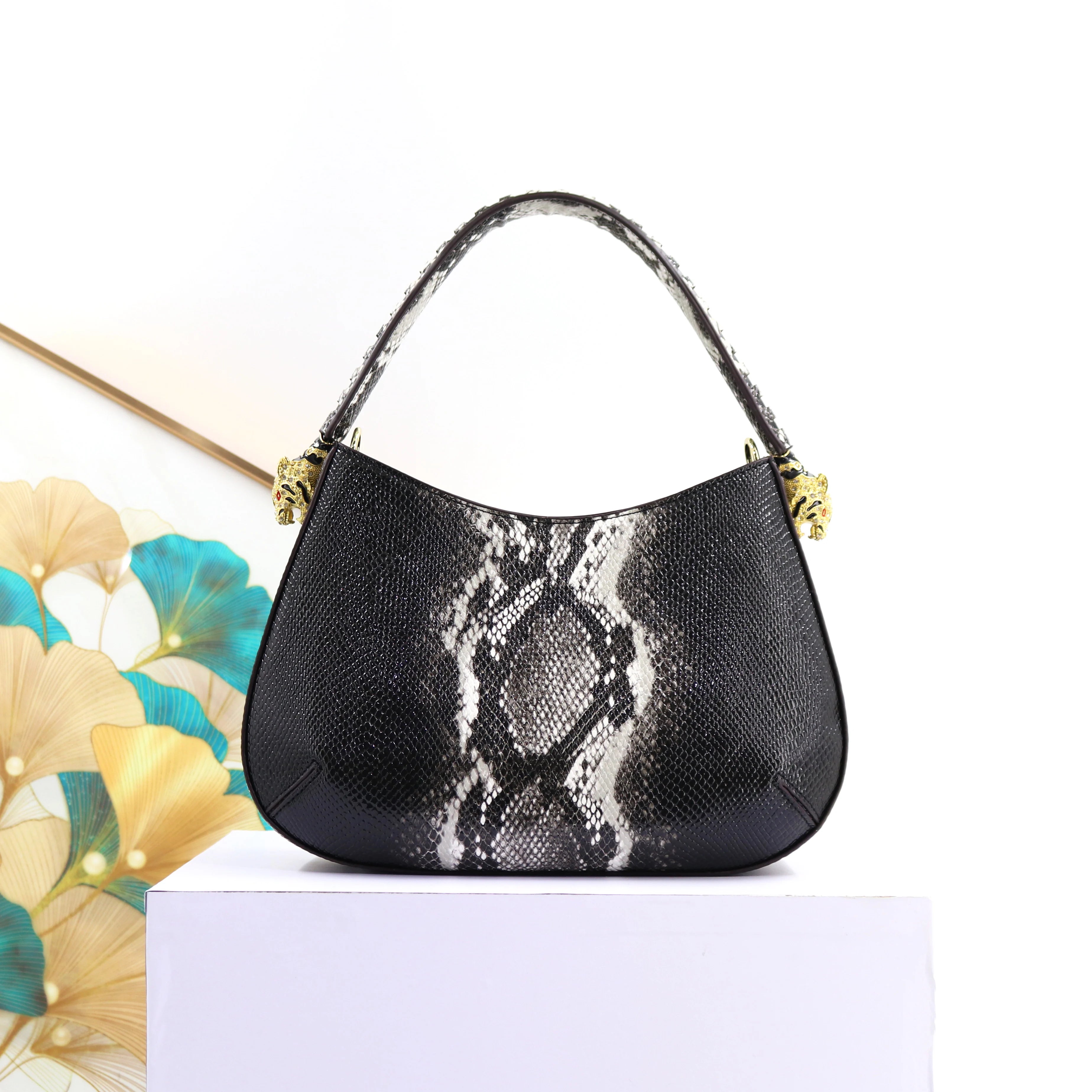 32cm black and white snakeskin print designer shoulder bag with gold tiger head accents and textured finish.