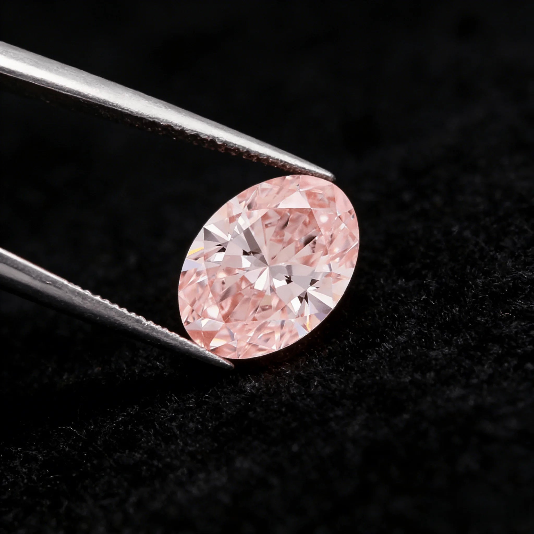 Oval fancy pink lab-grown diamond from side angle, crisp facet reflections