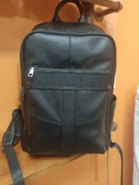 Black genuine leather designer backpack for women with front zipper pocket and adjustable shoulder straps.
