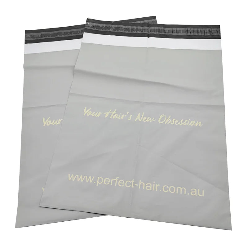 White plastic shipping bags with black band handles and printed branding