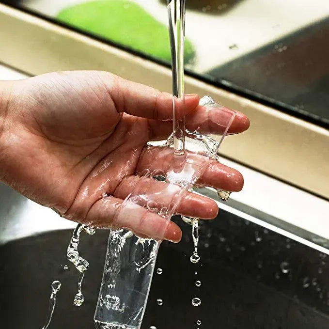 White mounting tape with water splashing over it, hands showing adhesive area