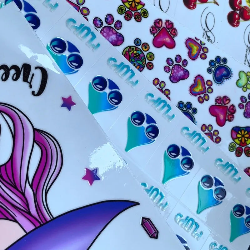 Vinyl die-cut sticker sheet with colorful cat faces, paw hearts, stars, and dots