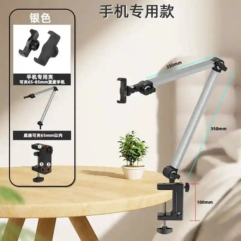 Silver articulated phone mount arm with a desk clamp, featuring adjustable joints and a spring-loaded phone holder.
