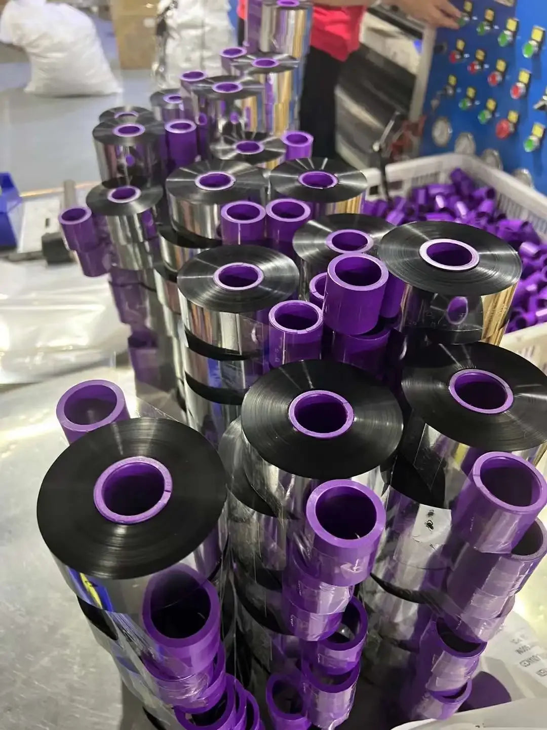 Stack of black wax-resin thermal transfer ribbon rolls with purple inner rings