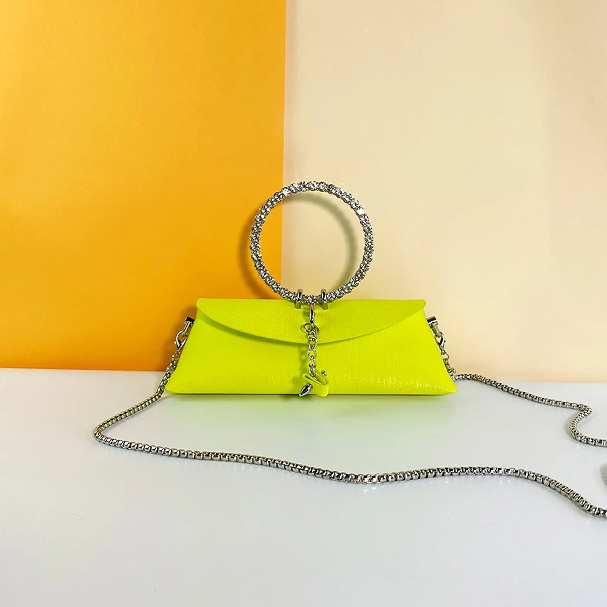Neon yellow luxury PU clutch trunk with rhinestone circle handle and detachable silver chain shoulder strap.