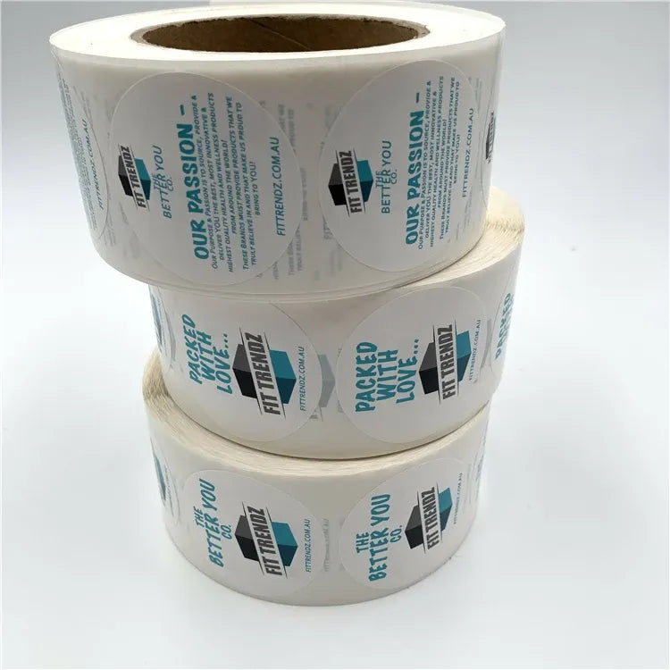 Three rolls of white custom printed label stickers with blue text and logos