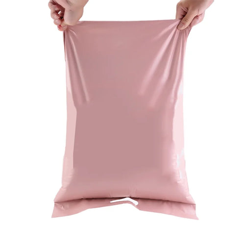 Pink 10x13 shipping mailer envelope bag, held open by hands