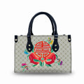 Luxury faux leather trunk handbag with beige skull pattern, black handles, and vibrant red Chinese motif embroidery.