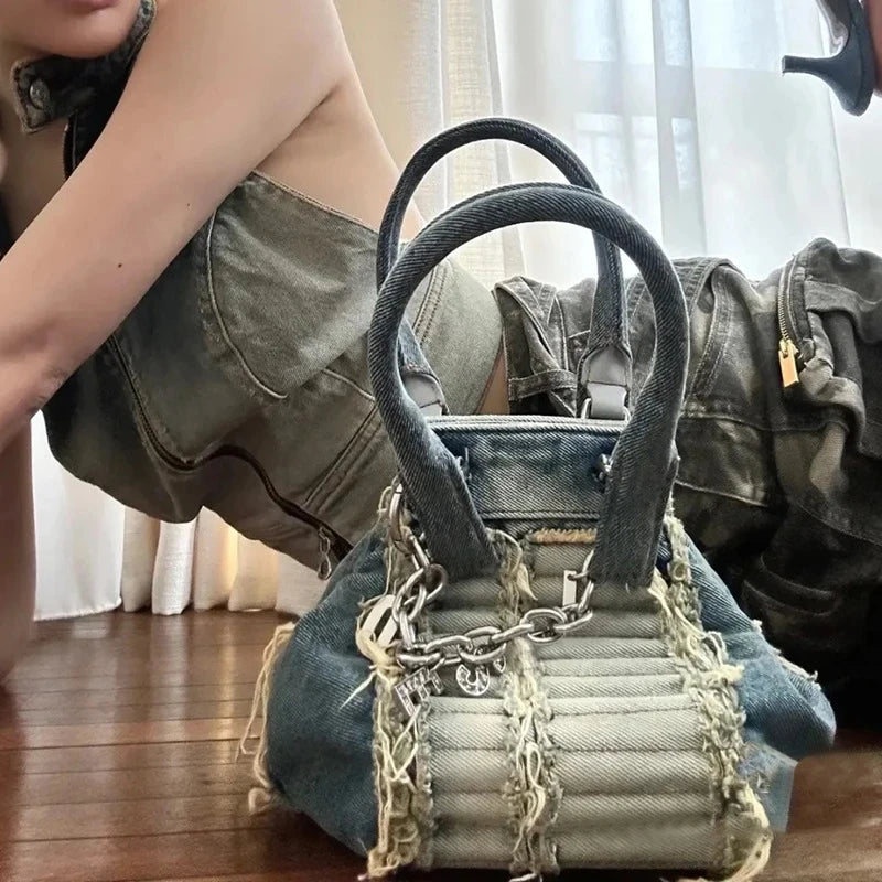 Vintage denim hobo bag with frayed edges, quilted texture, and silver chain detail. Luxury casual designer trunk purse.