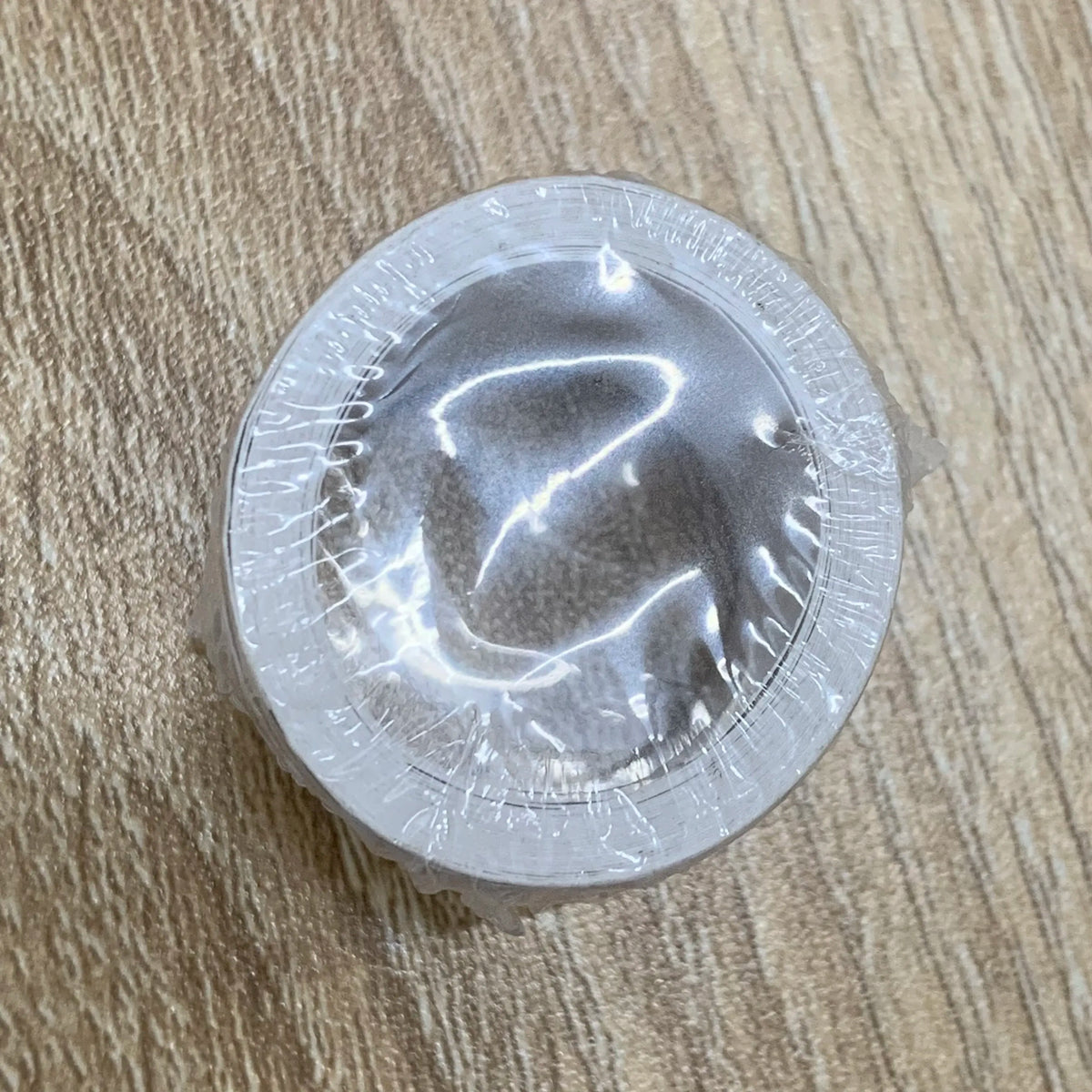 Single circular self-adhesive stamp in clear plastic sleeve, gray backing
