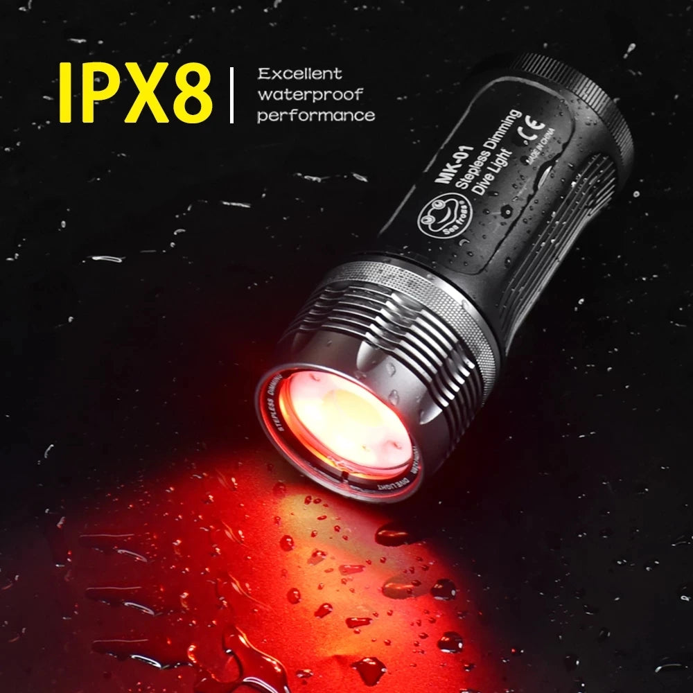 Black cylindrical waterproof LED dive light emitting a red beam on a wet surface.