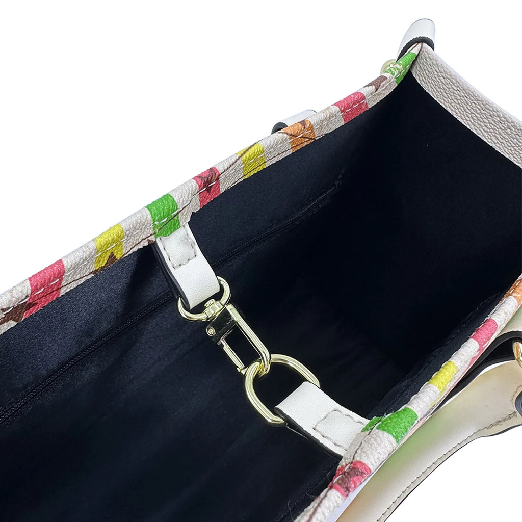 Luxury faux leather trunk handbag interior, multicolor pattern trim, black lining, and gold metal lobster clasp.