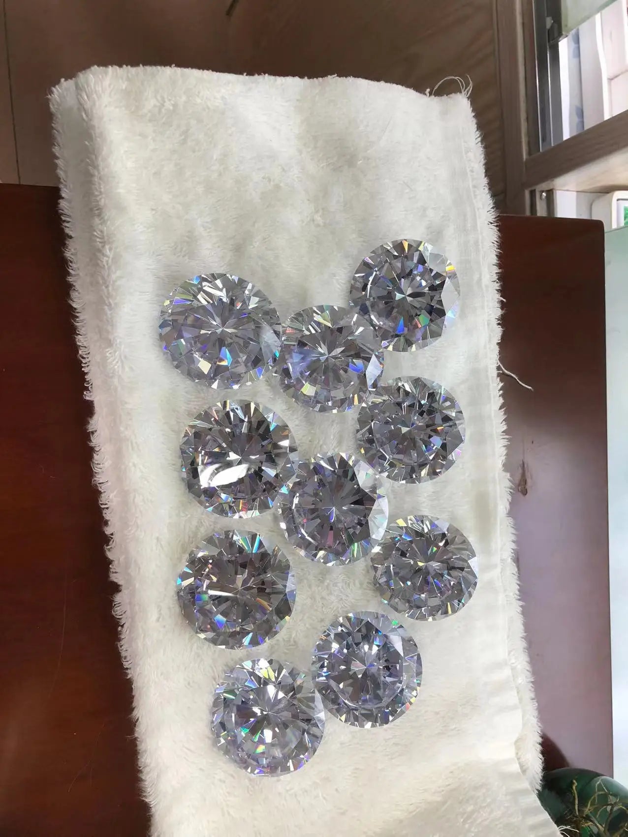 Loose round brilliant-cut cubic zirconia gemstones, white, shown on a soft case