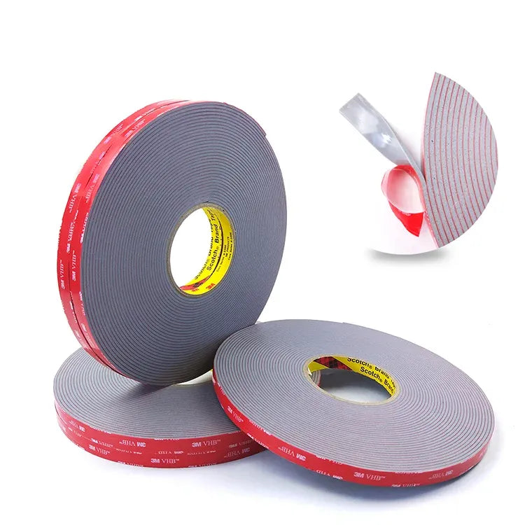 Double-sided acrylic foam tape rolls with gray tape and red adhesive edge; loose strip shown