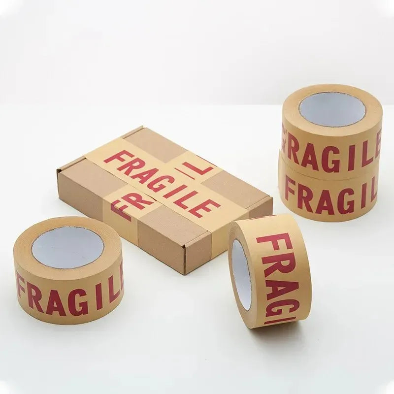 FRAGILE packing tape rolls and a taped cardboard box for shipping