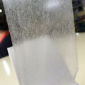 Close-up double-sided tissue tape, textured translucent surface and white adhesive backing