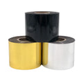 Hot stamping foil rolls with black, gold, and white ribbon rolls on a core