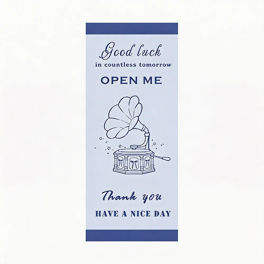 Blue rectangle seal sticker with “Good luck” “OPEN ME” and “Thank you”