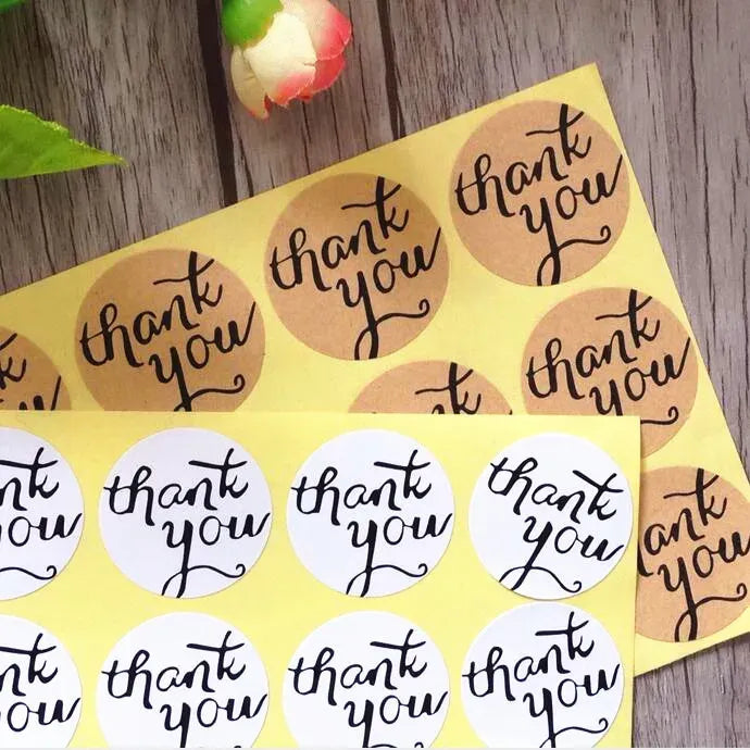 Sheet of round kraft adhesive seal stickers printed “thank you” in black.