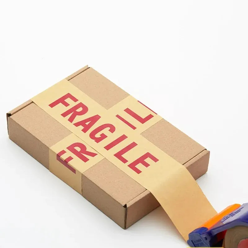 Cardboard parcel sealed with FRAGILE tape strip, securing a shipping box
