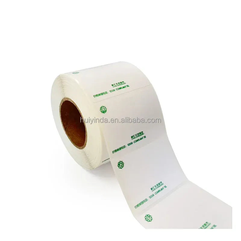 White thermal label roll with green icons and patterned printing on liner