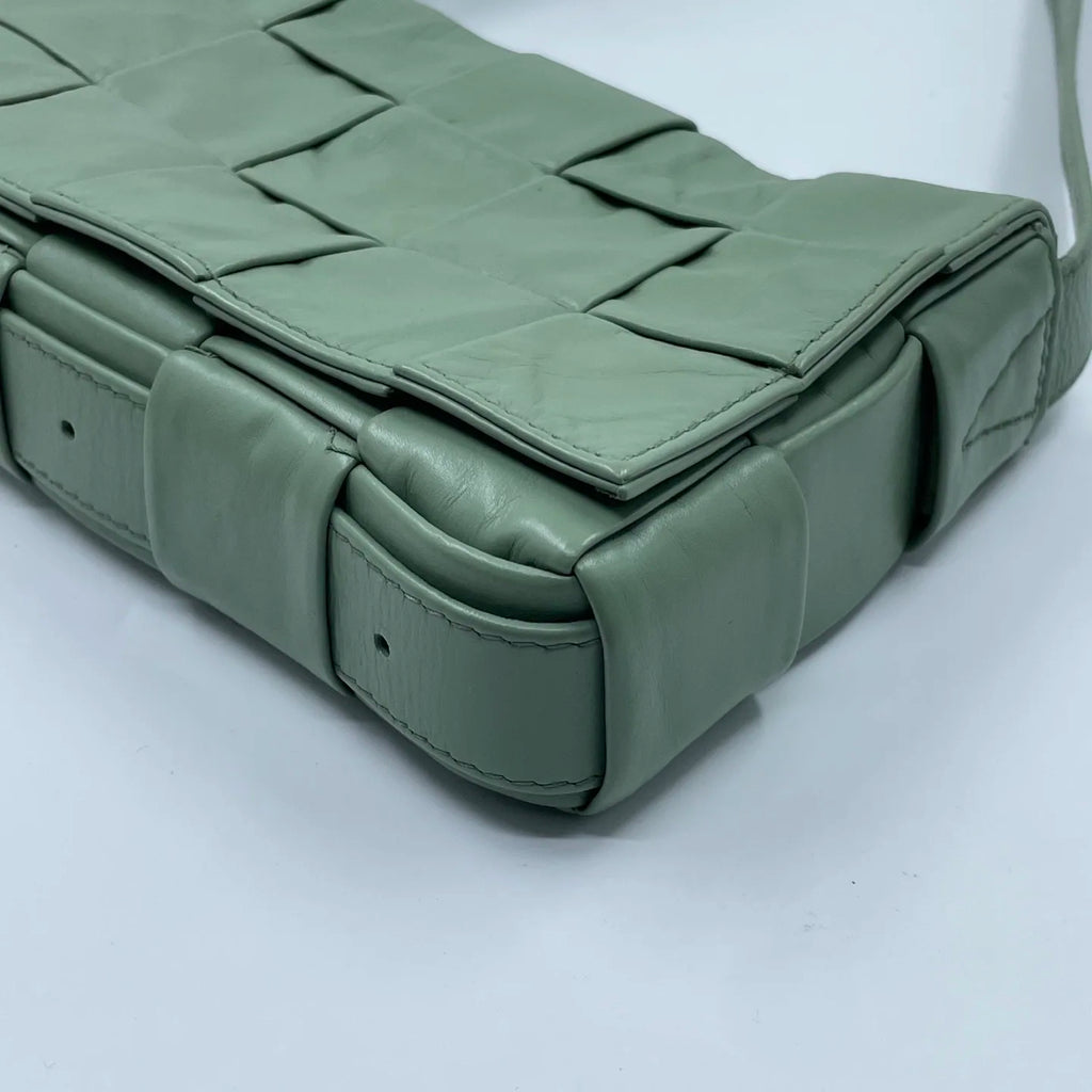 Light green designer shoulder bag in woven leather. Luxury pre-owned handbag with square weave pattern and strap.