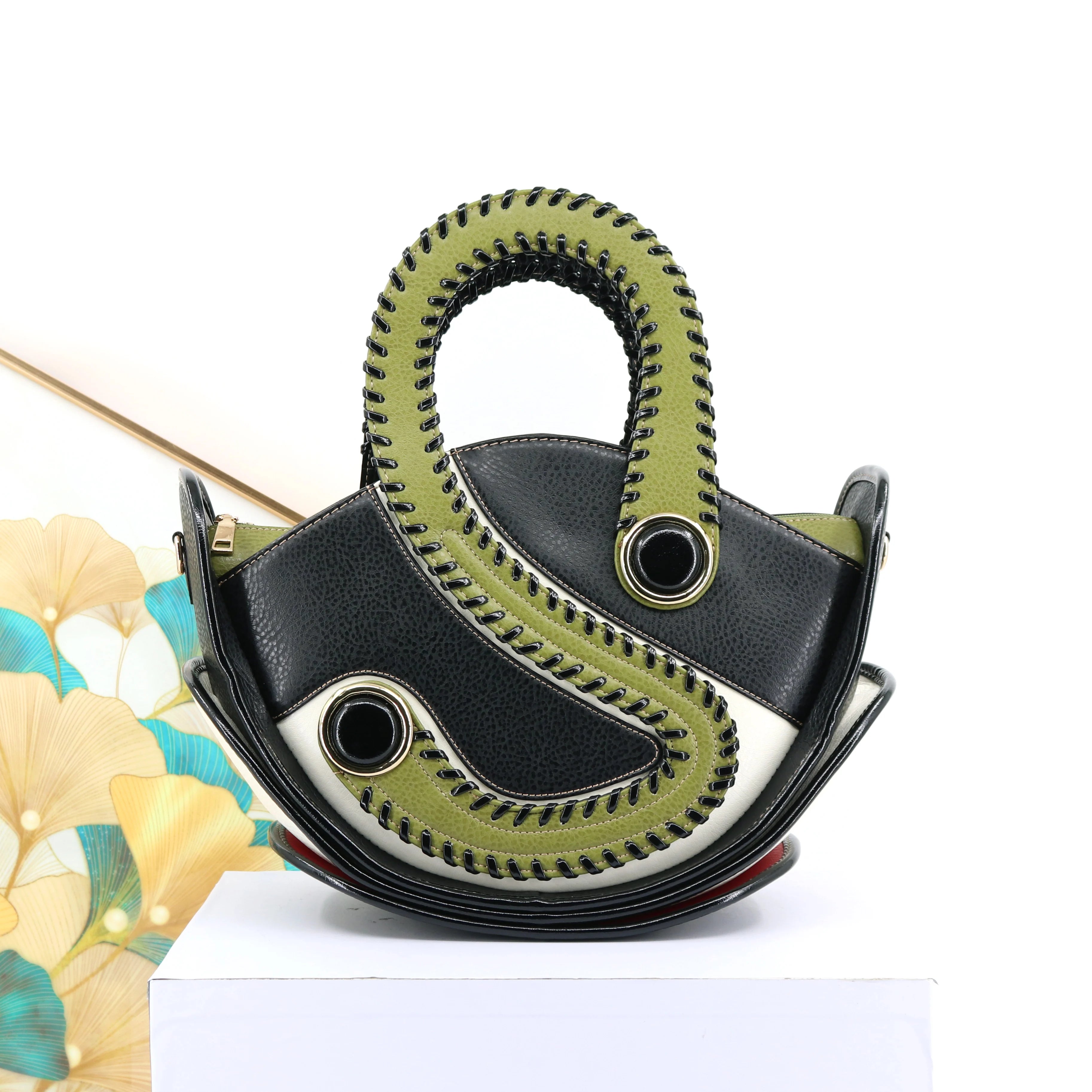 Unique black and olive green designer handbag with large capacity, contrast stitching, and sculptural modern style.