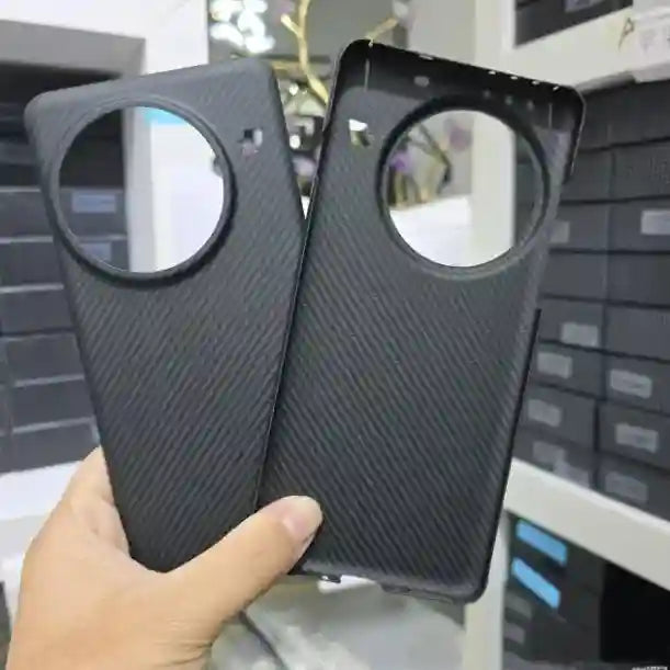 Two black, textured carbon fiber-style phone cases with large circular cutouts for camera lenses.