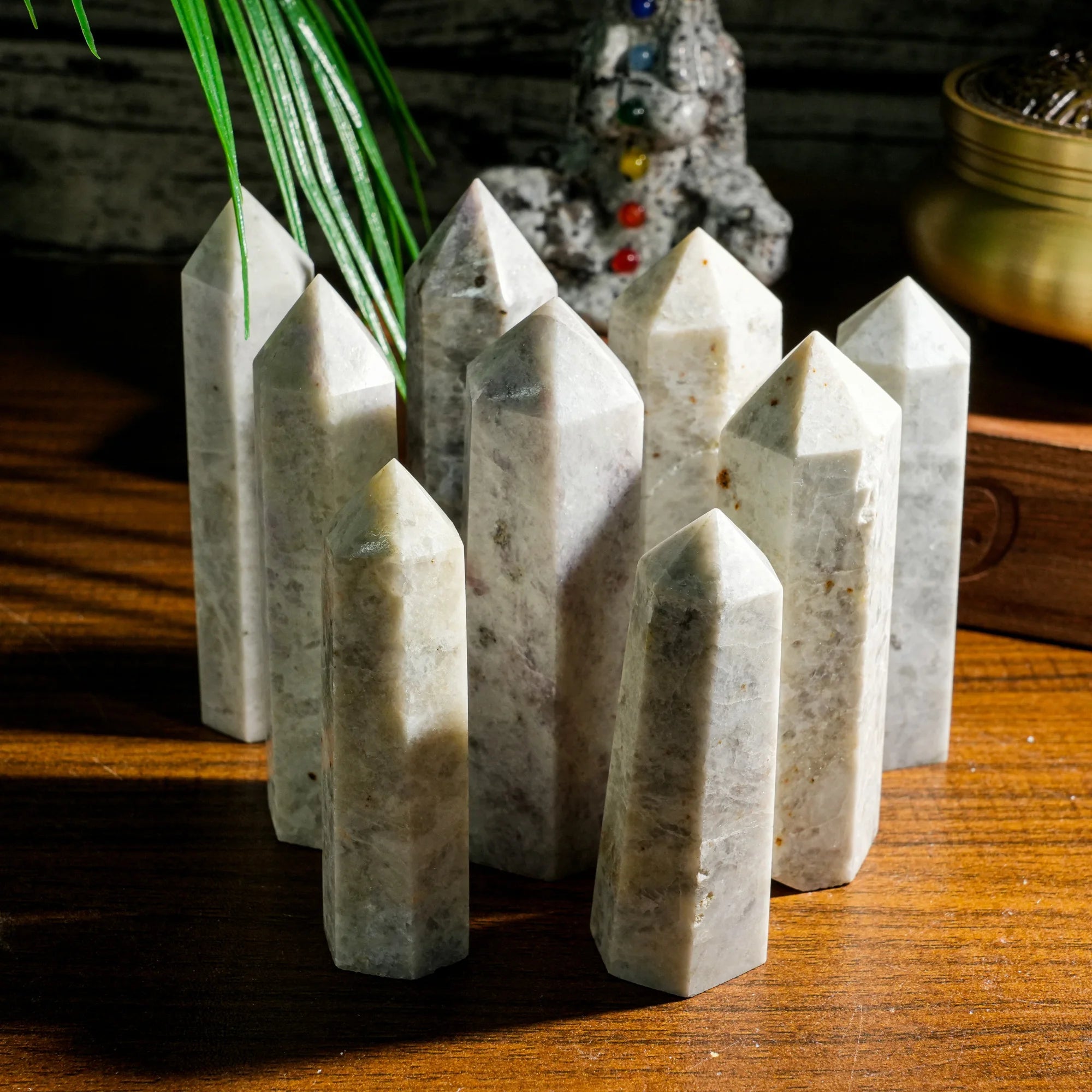 Natural gemstone crystal point tower with clustered pointed stones on a wooden surface.
