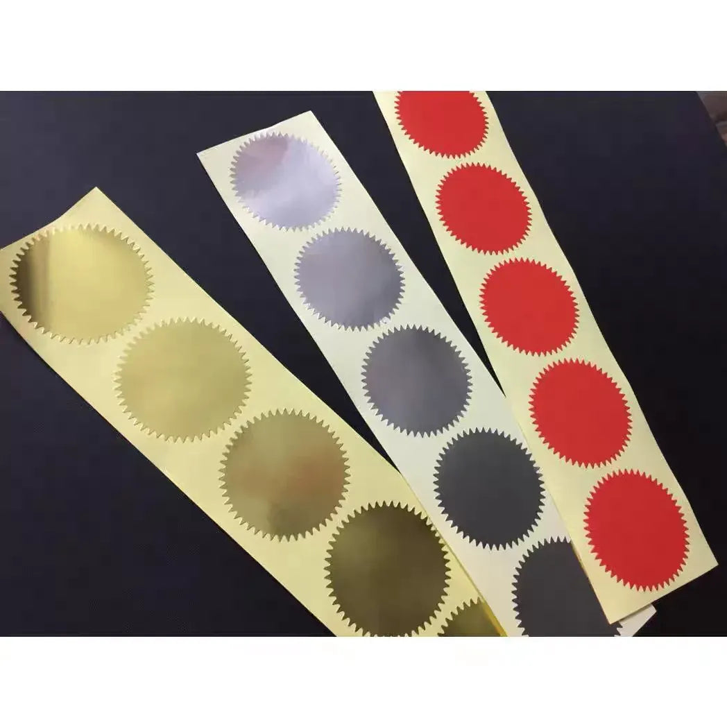Set of round scalloped stickers in gold, red, and dark gray on backing cards