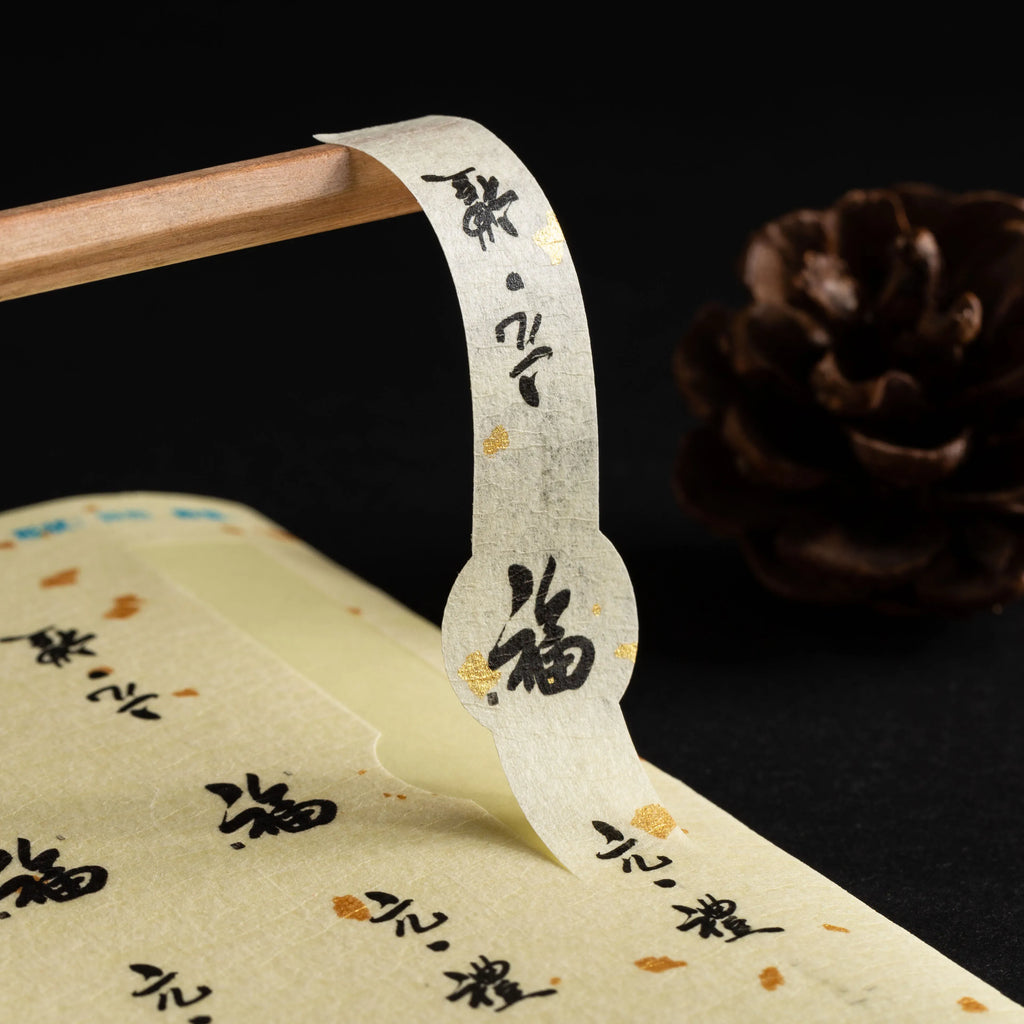 Strip of thank-you envelope stickers, cream with black Chinese characters along edge
